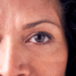 Close Up On Eyes Of Smiling Mature Woman In Studio